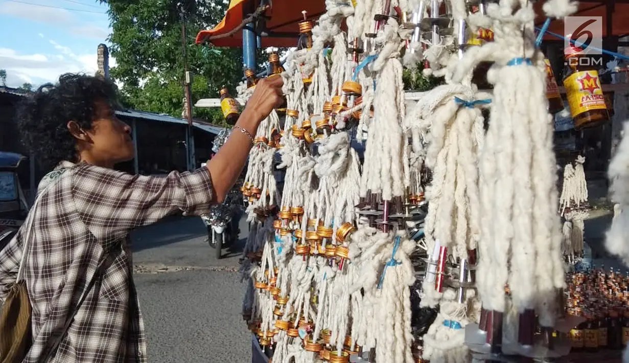 Pedagang merapikan pelita dagangannya yang dijual di Jalan Sam Ratulangi, Kota Gorontalo, Rabu (22/5/2019). Pelita ini terbuat dari botol bekas yang dipasangi sumbu. (Liputan6.com/Arfandi Ibrahim)