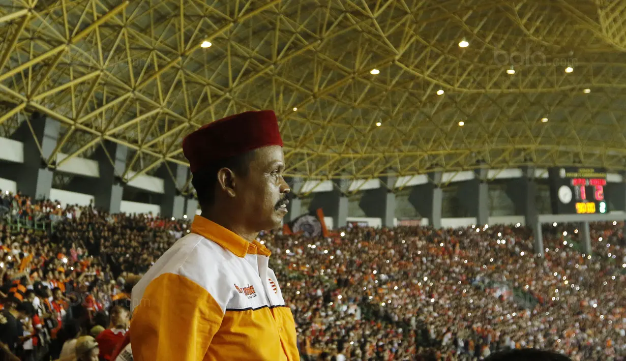 Seorang The Jakmania tampak serius saat menyaksikan laga terakhir Persija di Liga 1 di Stadion Patriot, Bekasi, Minggu (12/11/2017). Persija menang 2-1 atas Bhayangkara FC. (Bola.com/ M Iqbal Ichsan)