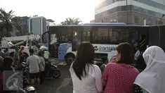 Sejumlah warga berdatangan ke lokasi bus TransJakarta yang terlibat kecelakaan dengan kereta api Senja Utama Solo di perlintasan kereta Mangga Dua, Jakarta, Kamis (19/5). Peristiwa tabrakan itu juga melibatkan mobil Avanza. (Liputan6.com/Faizal Fanani)