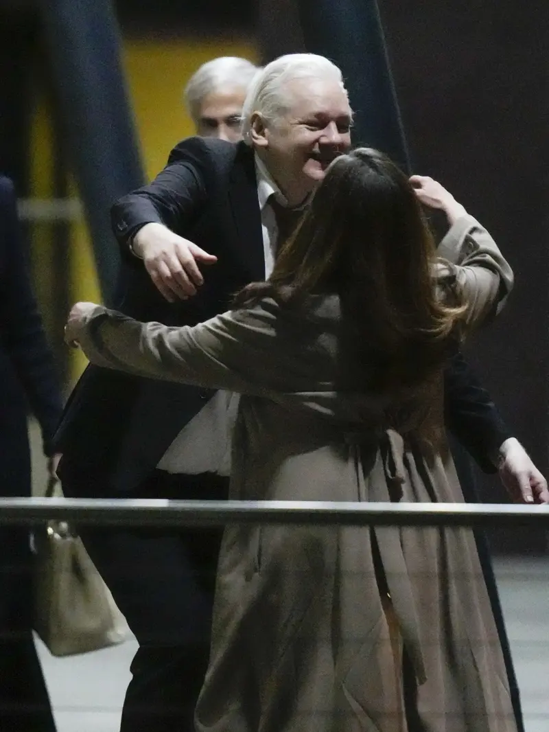 Pendiri Wikileaks Julian Assange setelah mendarat di pangkalan udara RAAF Fairbairn di Canberra, Australia Rabu, 26 Juni 2024 memeluk sang istri.(AP/Rick Rycroft)