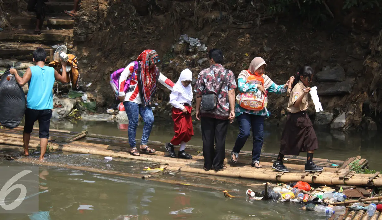 Sejumlah warga saat menyeberangi kali Ciliwung usai penggusuran di Kampung pulo, Jakarta, Jumat (21/8/2015). Penggusuran terkait rencana Pemprov DKI Jakarta yang akan melakukan normalisasi Kali Ciliwung. (Liputan6.com/Gempur Surya)