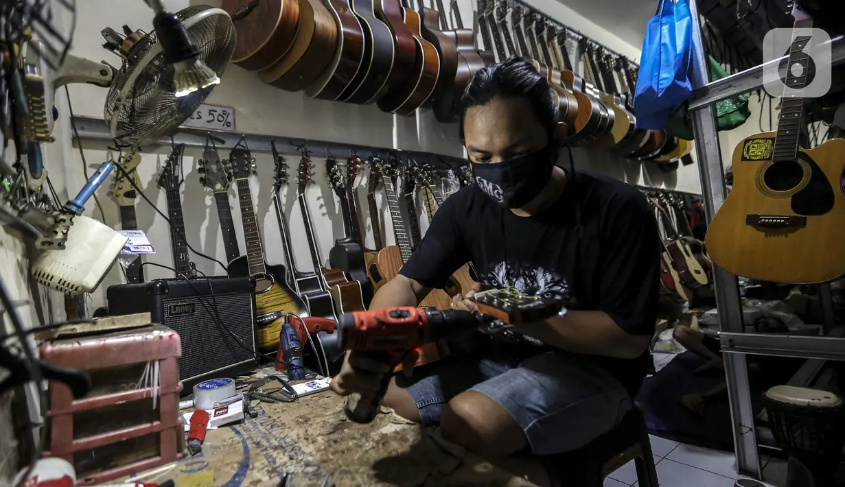 Harry saat mereparasi gitar klasik menjadi gitar listrik di toko kawasan Kedoya, Jakarta Barat, Selasa (9/2/2021). Selama pandemi COVID-19, servis gitar mengalami penurunan. (Liputan6.com/Johan Tallo)