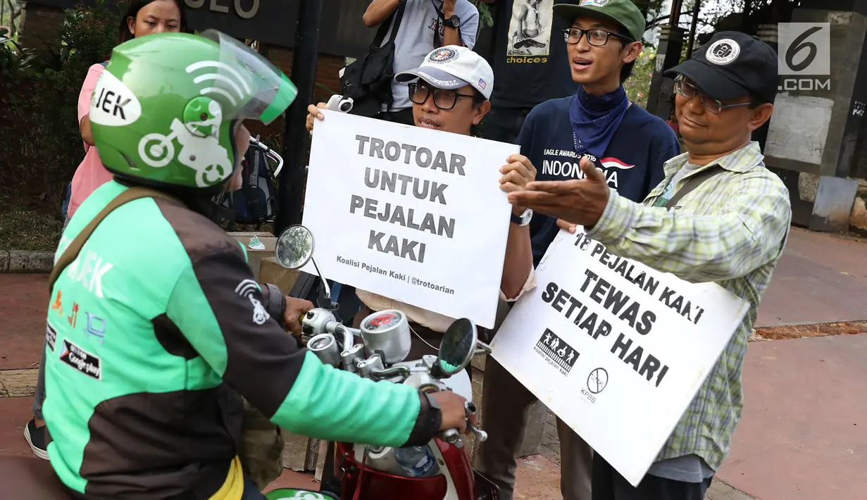 Aktivis Koalisi Pejalan Kaki menghadang pengendara yang menerobos trotoar di depan di Jalan Casablanca, Jakarta, Jumat (21/7). Aksi tersebut untuk mengedukasi pengendara agar menghormati hak pejalan kaki di trotoar. (Liputan6.com/ Immanuel Antonius)
