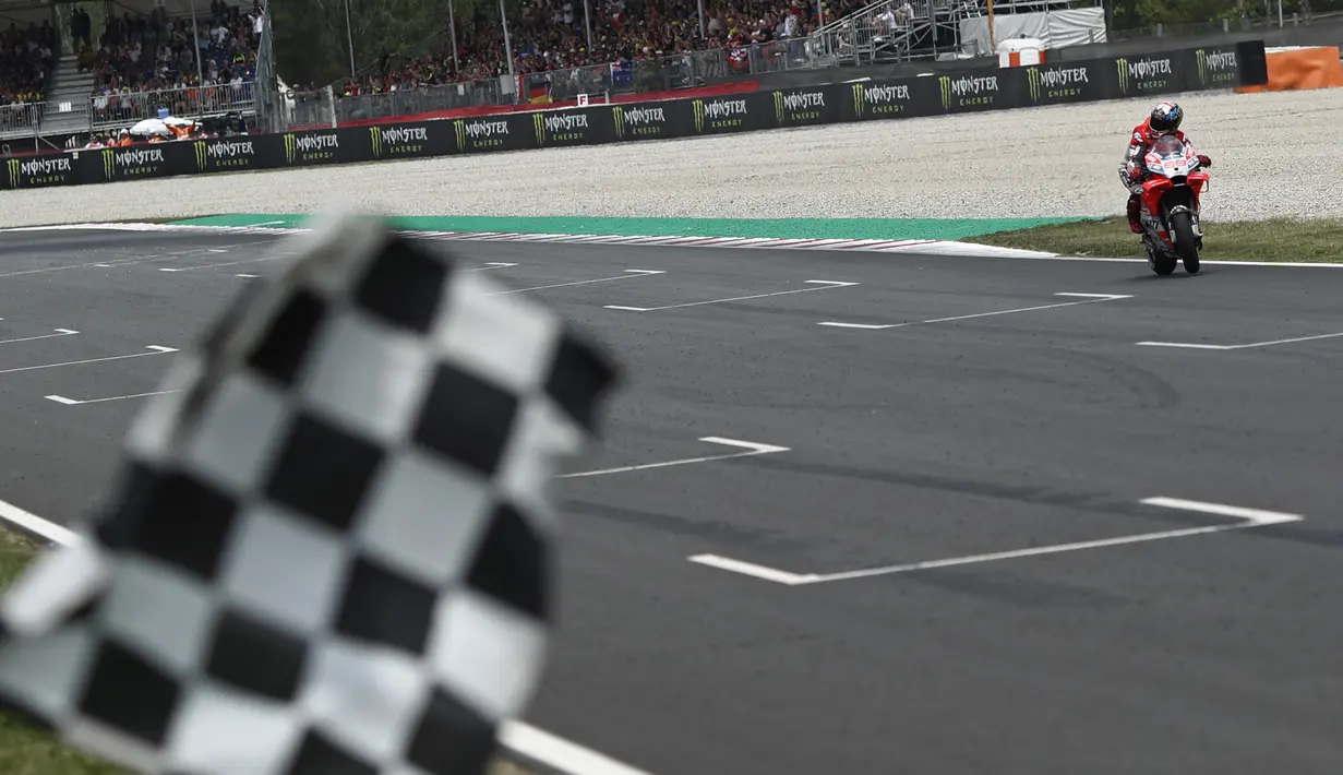 Pebalap Ducati, Jorge Lorenzo, finish pertama pada balapan MotoGP 2018 di Sirkuit Catalunya, Spanyol, Minggu (17/6/2018). Lorenzo menjadi yang tercepat dengan catatan waktu 40 menit 13,566 detik. (AP/Eric Alonso)