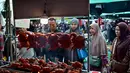 Ayam panggang dengan siraman saus santan berbumbu kental menjadi salah satu menu favorit warga lokal untuk berbuka puasa bersama keluarga. Tampak dalam foto, orang-orang membeli makanan untuk berbuka puasa pada hari pertama bulan suci Ramadan 1447 Hijriah di sebuah pasar di provinsi Narathiwat, Thailand selatan, pada Kamis 19 Februari 2026. (Madaree TOHLALA/AFP)