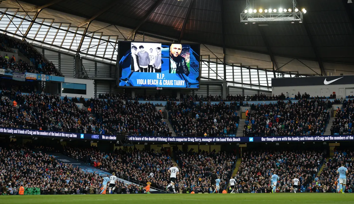 Sebuah layar menampilkan foto para anggota band  Viola Beach dan manajer mereka menjelang laga Manchester City dan Tottenham Hotspur di Inggris, Minggu (14/2). Empat personel band asal Inggris itu tewas dalam kecelakaan mobil di Swedia. (Oli SCARFF/AFP)