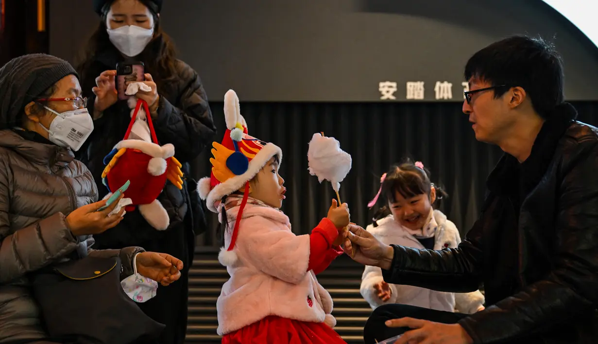 Orang-orang mengunjungi Taman Yu menjelang Tahun Baru Imlek Kelinci, di Shanghai pada 9 Januari 2023. Di dalam taman terdapat batu giok berpori yang indah berukuran 3,3 meter dengan beran 5 ton. Menurut ceritanya, batu giok ini rencananya akan dibawa ke istana kekaisaran untuk dipersembahkan kepada Kaisar Huizong dari Dinasti Song Utara, sekitar tahun 1100-26. (AFP/Hector Retamal)