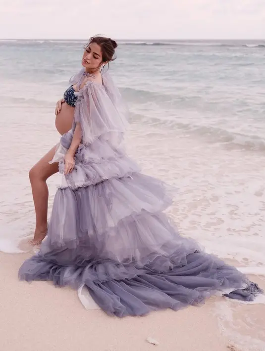 Selain itu, ia pun mengenakan robe ungu layering yang indah denga bralatte biru navynya. Ia tampil bak dewi yang berpose di pinggir pantai. Robe tersebut karya Cynthia Tan. @inijedar