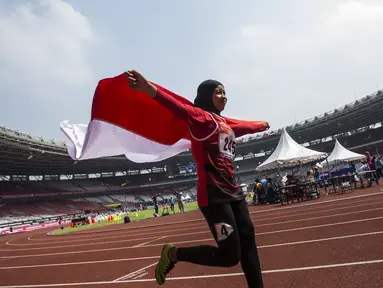 Pelari Indonesia, Tiarani Karisma, melakukan selebrasi usai meraih medali emas Asian Para Games cabang atletik nomor lari 100 meter T42 / T63 di SUGBK, Jakarta, Rabu (10/10/2018). (Bola.com/Vitalis Yogi Trisna)