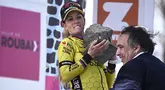 Ekspresi pembalap Team Visma-Lease, Pauline Ferrand-Prevot saat menjunjung trofi kemenangan Paris Roubaix Femmes 2025 pada Sabtu (12/04/2025) waktu setempat. Perlombaan tersebut menempuh 148,5 km dari Denain hingga Roubaix, Prancis. (AFP/Julien De Rosa)