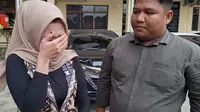 Korban kekerasan dalam rumah tangga yang dilakukan oknum polisi di Polresta Pekanbaru mengusap matanya mengingat penganiayaan yang pernah dialaminya. (Liputan6.com/M Syukur)