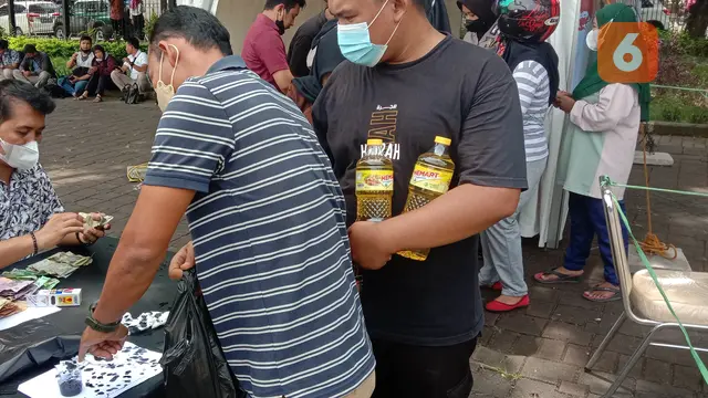 Warga Yang Sudah Dapakan Minyak Goreng, Menyelupkan Jari Ke Tinta. (Rabu, 09/03/2022). (Liputan6.com/Yandhi Deslatama).