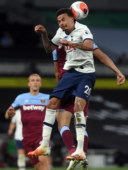 Gelandang  Tottenham Hotspur, Dele Alli  berebut bola udara dengan pemain West Ham pada pertandingan lanjutan Liga Inggris di Stadion Tottenham Hotspur di London (23/6/2020). Tottenham menang 2-0 atas West Ham. (AFP/Pool/Neil Hall)