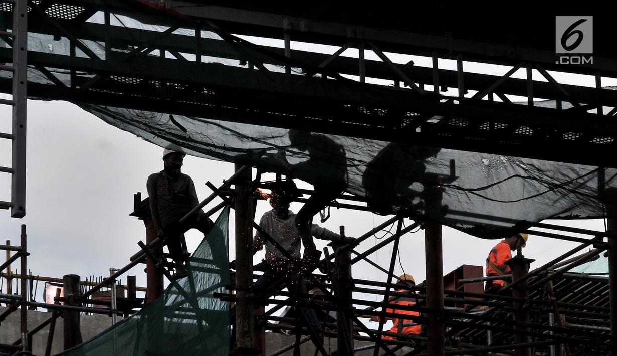 Aktivitas pekerja menyelesaikan proyek LRT Jabodebek di kawasan Cibubur, Jakarta, Senin (18/2). Tarif flat untuk moda transportasi massal ini ditetapkan setelah mendapat kepastian subsidi dari pemerintah. (Merdeka.com/Iqbal S. Nugroho)