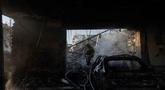 Seorang petugas pemadam kebakaran berjalan melewati dealer mobil yang rusak akibat serangan rudal dan drone besar-besaran Rusia di Kyiv pada Selasa 2 Juni 2026, di tengah invasi Rusia ke Ukraina. (Tetiana DZHAFAROVA/AFP)
