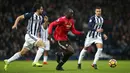 Pemain Manchester United Romelu Lukaku menggiring bola dengan kawalan pemain West Bromwich Albion pada lanjutan Premier League di The Hawthorns Stadium, Minggu (17/12). Lukaku mencetak satu dari dua gol kemenangan 2-1 MU. (Nick Potts/PA via AP)