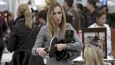 Seorang wanita membawa sejumlah sepatu yang dijual dengan harga murah selama perayaan Black Friday di Macy Herald Square, New York,(26/11). Black Friday jatuh pada sehari tepat setelah perayaan Thanksgiving. (REUTERS/Andrew Kelly)