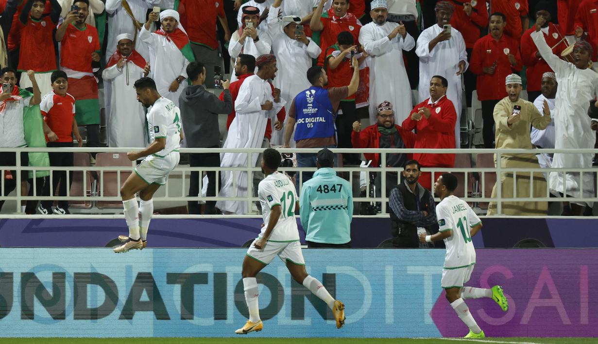 Selebrasi para pemain Timnas Oman setelah Muhsen Al Ghassani menjebol gawang Kirgistan pada laga ketiga Grup F Piala Asia 2023 di Abdullah bin Khalifa Stadium, Doha, Qatar, Kamis (25/1/2024). (AFP/Karim Jaafar)