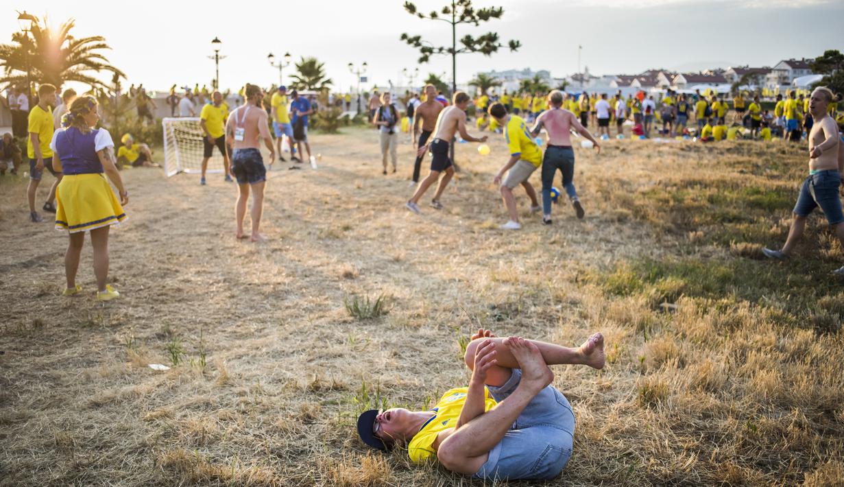 Sejumlah suporter Swedia bergembira di sekitar Pantai Sochi, Jumat (22/6/2018). Para suporter bersiap untuk menyaksikan laga Piala Dunia 2018 antara Swedia melawan Jerman. (AFP/Odd Andersen)