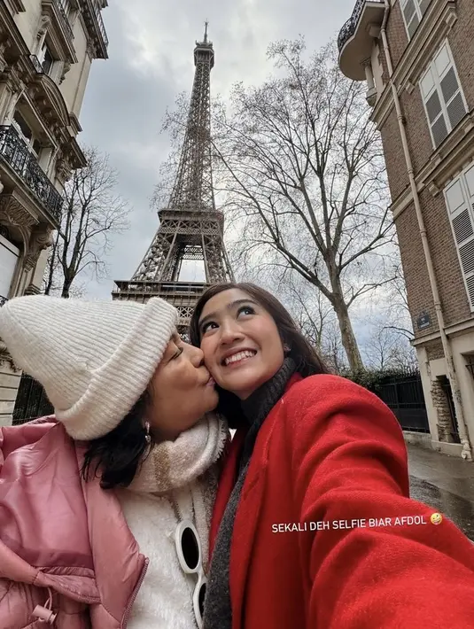 Berada di menara Eiffel, Febby mengenakan coat merah. Sementara sang ibunda mengenakan padding jaket pink dengan inner putih berbulu. [@febbyrastanty]