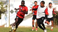 Makan Konate melewati Sunarto dalam latian Arema, Kamis (23/8/2018). (Bola.com/Iwan Setiawan)