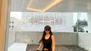 Gaya chic dan stylish serba hitam Ningning yang mengenakan sleeveless top, midi skirt, dan beret hat hitam.