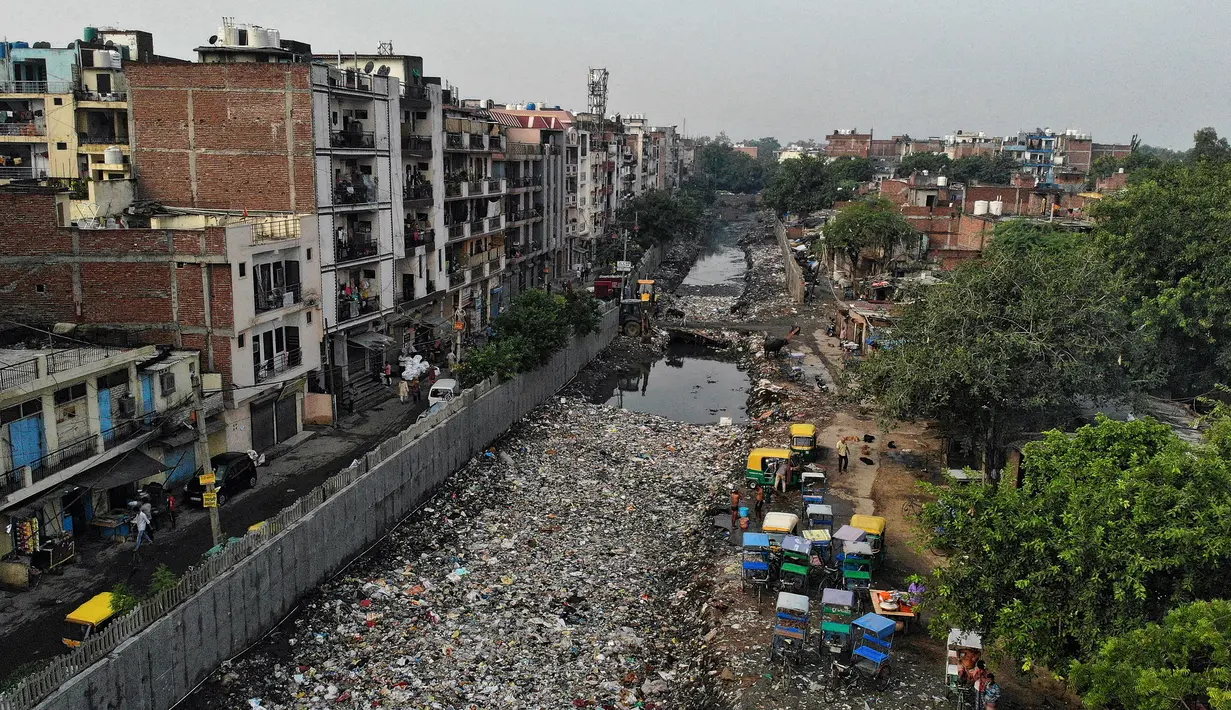 Pandangan udara menunjukkan saluran pembuangan air limbah yang dipenuhi sampah di lingkungan berpenghasilan rendah di New Delhi, India (4/10/2019). (AFP Photo/Noemi Cassanelli)