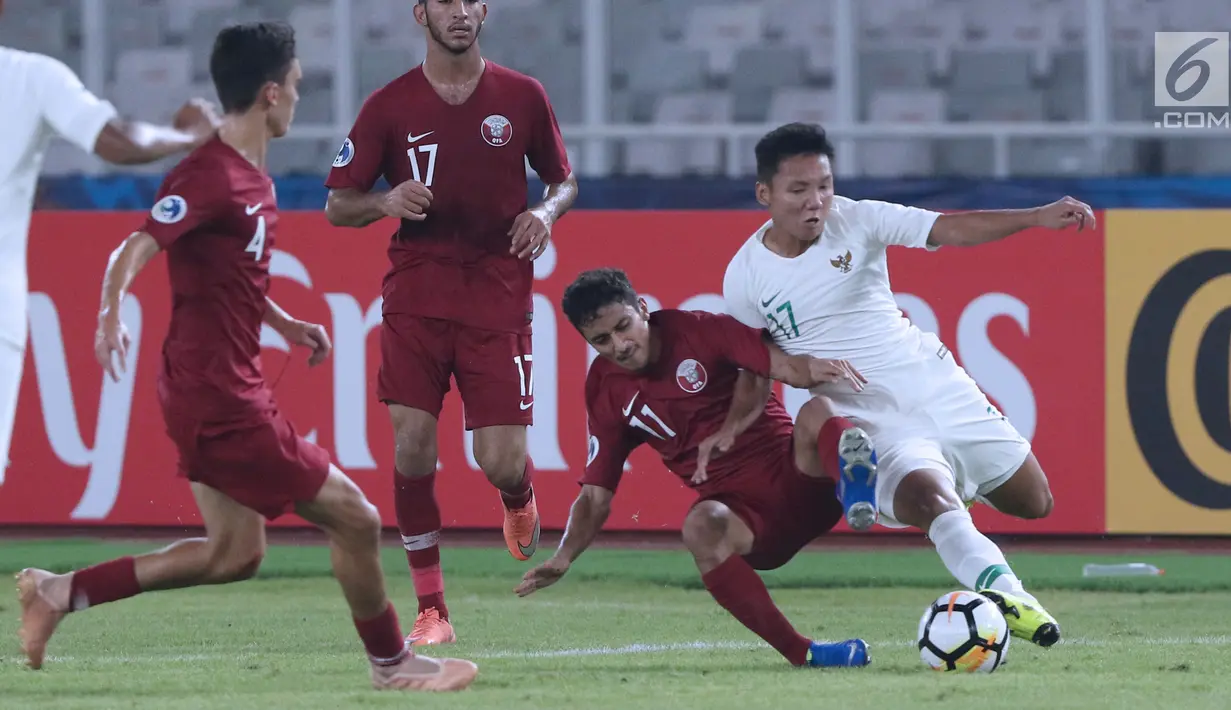 Pemain tengah Indonesia U-19, Syarian Abimanyu (kanan) berebut bola dengan pemain Qatar U-19, Abdulla Nasser M Almurisi pada penyisihan Grup A Piala AFC U-19 2018 di Stadion GBK, Jakarta, Minggu (21/10). (Liputan6.com/Helmi Fithriansyah)