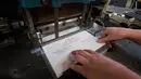 Mesin mencetak undangan pernikahan Pangeran Harry dan Meghan Markle di bengkel perusahaan Barnard and Westwood,  London, Kamis (22/3). Mesin pencetak stampel masih menggunakan alat tradisional, yaitu sebuah mesin dari tahun 1930-an. (AP Photo)
