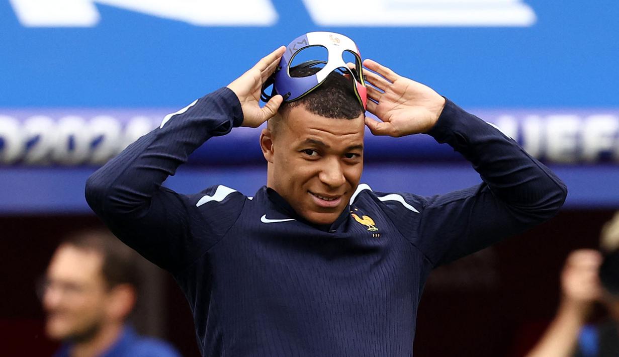 Pemain Prancis, Kylian Mbappe melepas topengnya setelah sesi latihan jelang laga melawan Belanda pada laga Grup C Euro 2024 di Leipzig Stadium, Leipzig, Jerman, Kamis (20/06/2024) waktu setempat. (AFP/Franck Fife)