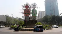 Kendaraan melintas saat Petugas PPK Kemayoran mengecat ulang Monumen Ondel-Ondel di Jalan Benyamin Sueb, Jakarta, Selasa (3/7). Pengecatan tersebut dalam rangka persiapan menyambut Asian Games pada Agustus mendatang. (Liputan6.com/Arya Manggala)