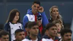 Luis Suarez (tengah) menyeka matanya di antara putrinya Delfina (kiri) dan istrinya Sofia Balbi saat menonton video selama presentasinya sebagai pemain baru Nacional di Stadion Gran Parque Central, di Montevideo, pada 31 Juli, 2022. Luis Suarez kembali ke Uruguay untuk bergabung dengan Nacional, klub tempat ia memulai karirnya 17 tahun lalu sebagai salah satu striker terbaik di generasinya. (AFP/Pablo Porciuncula)