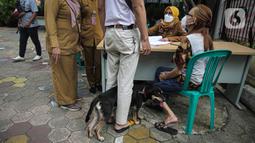 Paramedis Puskeswan DKP3 Jakarta Selatan melakukan pendataan saat pelaksanaan vaksinasi antirabies secara gratis di kawasan Tebet, Jakarta, Selasa (16/11/2021). Vaksinasi juga dilakukan agar Provinsi DKI Jakarta bebas rabies. (Liputan6.com/Faizal Fanani)