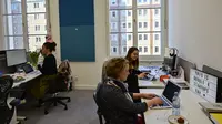 Sejumlah karyawan berada di meja kerja mereka pada hari pembukaan kantor baru raksasa mesin pencari internet, Google, di Berlin, Selasa (22/1). Google kembali membuka kantor cabang yang baru di ibu kota Jerman tersebut. (Photo by Tobias SCHWARZ / AFP)