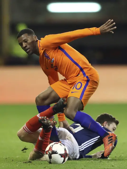 Pemain Belanda, Georginio Wijnaldum (atas) merebut bola dari pemain Skotlandia, Andrew Robertson pada laga persahabatan di Pittodrie, Aberdeen, Skotlandia (9/11/2017). Belanda menang 1-0. (Andrew Milligan/PA via AP)