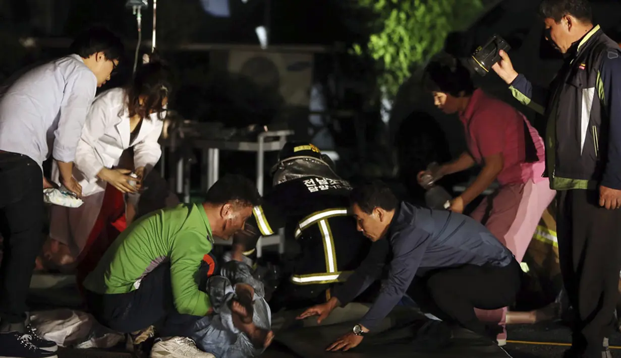 21 orang dinyatakan tewas dan delapan lainnya terluka akibat api yang membakar rumah sakit khusus kaum manula di Jangseong, Korea Selatan. Tampak beberapa petugas RS sedang mengevakuasi para korban, (28/5/2014). (REUTERS/Hyung Min-woo/Yonhap)