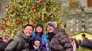 Ernest Prakasa beserta istri dan kedua anaknya merayakan Natal tahun ini di Amerika Serikat. Mereka pun berfoto di depan pohon Natal dengan mengenakan baju musim dinginnya. [@ernestprakasa]
