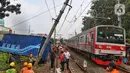 Petugas melakukan evakuasi truk yang menabrak tiang penyangga kabel KRL di antara Perlintasan Pondok Ranji - Kebayoran,Jakarta, Selasa (25/7/2023). (Liputan6.com/Angga Yuniar)