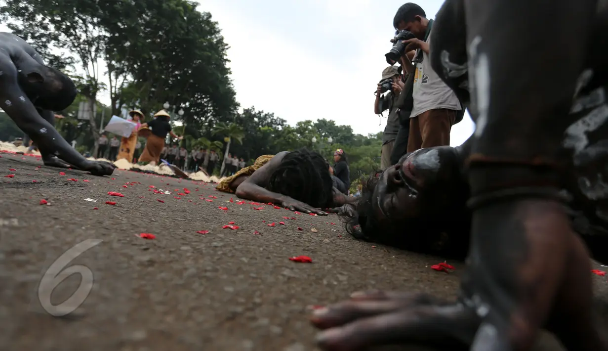 Sejumlah warga Batang bersama aktivis Greenpeace melakukan aksi teatrikal di depan Istana Merdeka, Jakarta, Rabu (3/6). Dalam aksinya mereka menuntut Presiden Jokowi menghentikan rencana pembangunan PLTU batubara di Batang. (Liputan6.com/Faizal Fanani)