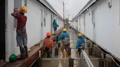 Aktivitas pekerja menyelesaikan pembangunan hunian sementara untuk warga korban banjir bandang dan tanah longsor di di Aceh Tamiang, provinsi Aceh, pada Kamis 8 Januari 2026. Menggandeng PT PP (Persero) Tbk (PTPP), Badan Pengelola Investasi (BPI) strategis Indonesia, atau dikenal sebagai Daya Anagata Nusantara (Danantara) membangun hunian sementara tanggap darurat bagi warga terdampak banjir. (ADITYA AJI/AFP)