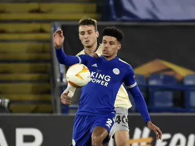 Bek Leicester City, James Justin berebut bola dengan gelandang AEK Athens, Mario Mitaj pada pertandingan Grup G Liga Europa di King Power Stadium, Jumat (11/12/2020) dinihari WIB. Leicester City memastikan diri keluar sebagai juara Grup G berkat kemenangan 2-0 atas AEK Athens.  (AP Photo/Rui Vieira)