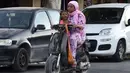 Seorang perempuan Tunisia dan anaknya menaiki skuter ketika kasus baru infeksi Corona di sana melonjak, di kota Gabes, Rabu (27/8/2020). Tunisia pada 25 Agustus 2020 melaporkan peningkatan tertinggi kasus baru Covid-19 dibandingkan minggu sebelumnya. (FETHI BELAID/AFP)
