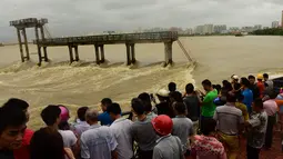 Sejumlah warga berdiri di dekat sungai setelah Topan Sarika menghantam kawasan hit Qionghai, Provinsi Hainan,  Tiongkok, (18/10).  (REUTERS/Stringer) 