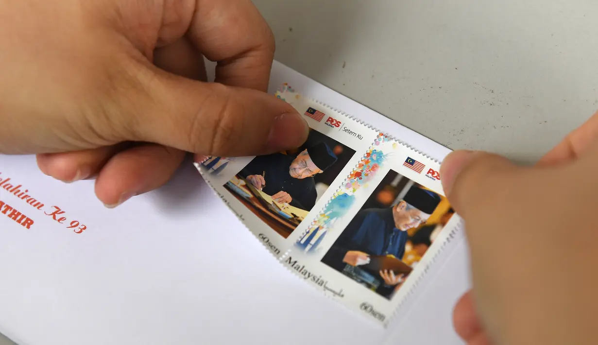 Prangko bergambar PM Malaysia Mahathir Mohamad dijual di sebuah kantor pos di Kuala Lumpur, Selasa (10/7). Prangko bergambar Mahathir ini dijual dalam edisi terbatas. (Mohd RASFAN/AFP)