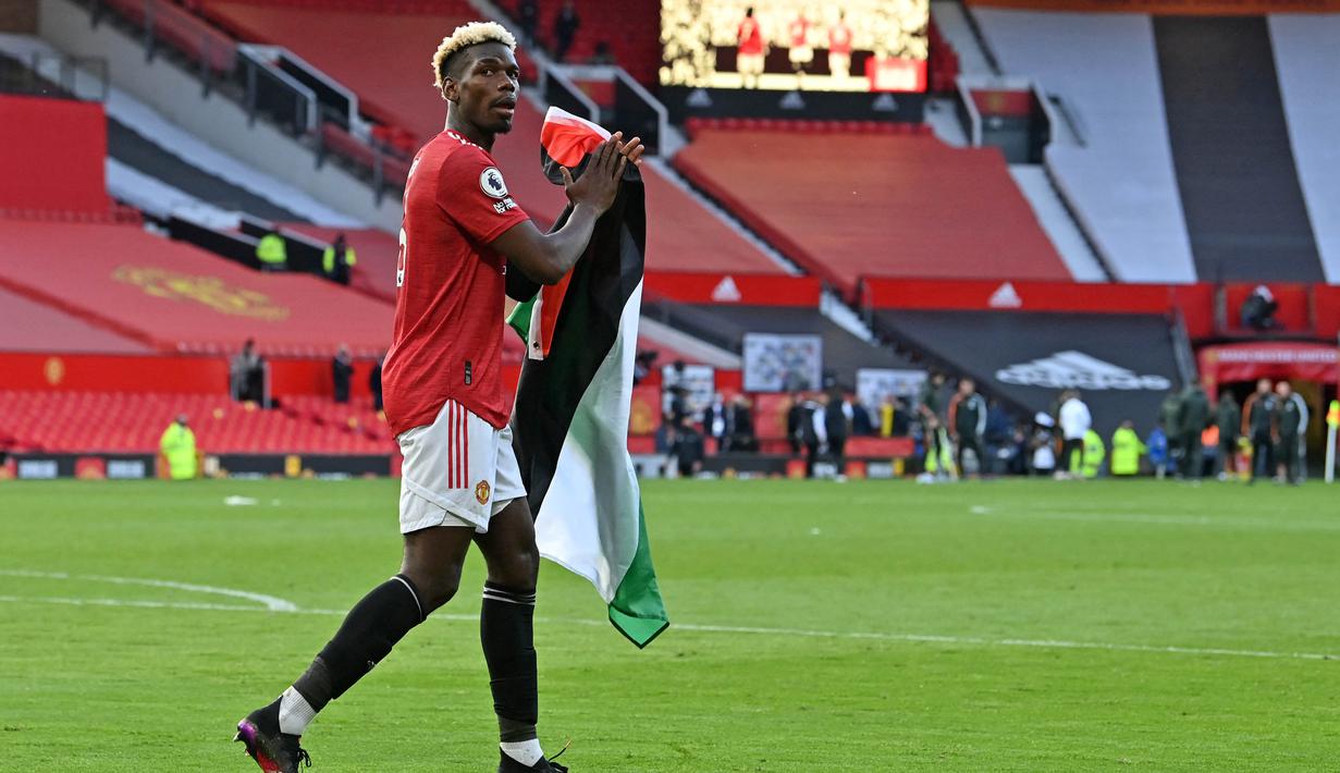 Segera setelah peluit panjang pertandingan berbunyi, Pogba menghampiri tribun penonton untuk mengambil bendera Palestina dari seorang suporter Manchester United. (Foto: AFP/Pool/Paul Ellis)