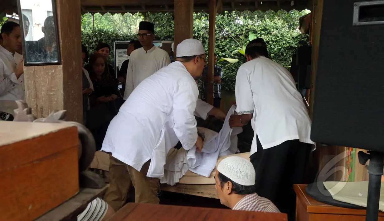 Sejumlah kerabat tampak mengkafani jenazah Didi Petet di musala di rumah kediaman almarhum di kawasan ciputat, Tangerang Selatan, Jumat (15/5/2015). Didi Petet meninggal di usia 58 tahun karena diduga menderita asam lambung. (Liputan6.com/Helmi Afandi)