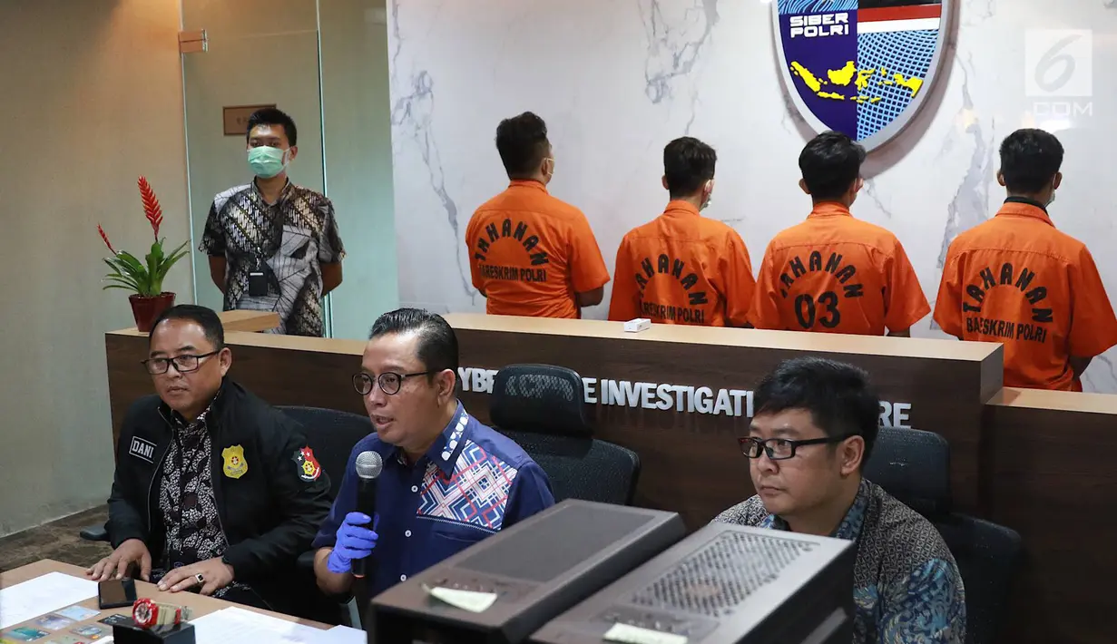 Kabag Penum Divisi Humas Polri Kombes Asep Adi Saputra (tengah) didampingi Kasubdit I Tindak Pidana Siber Bareskrim Polri Kombes (Pol) Dani Kustoni (kiri) menunjukkan tersangka beserta barang bukti kasus tindak pidana hacking server Indomaret di Jakarta, Jumat (12/4). (Liputan6.com/ImmanuelAntonius)