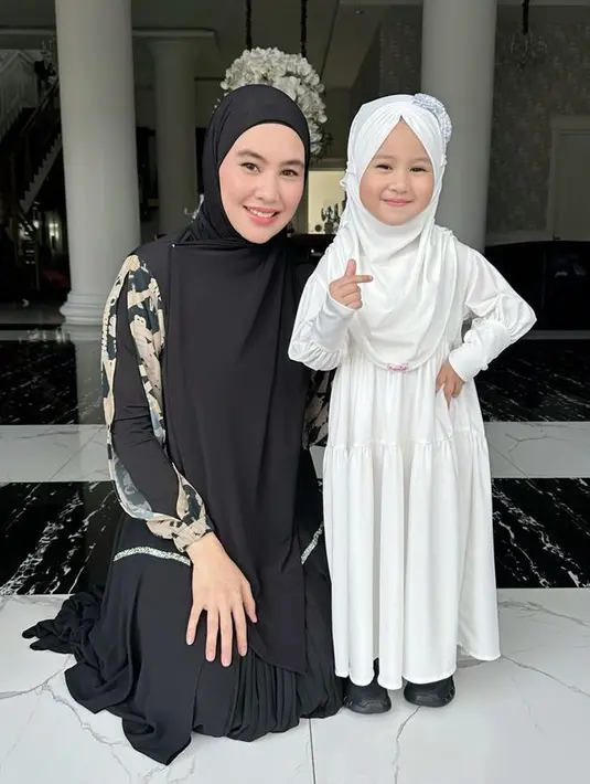 Ia juga tampil imut dengan dress putih ruffle yang diserasikan dengan kerudung instannya. Dipadukan sepatu hitam. [@kartikaputriworld]