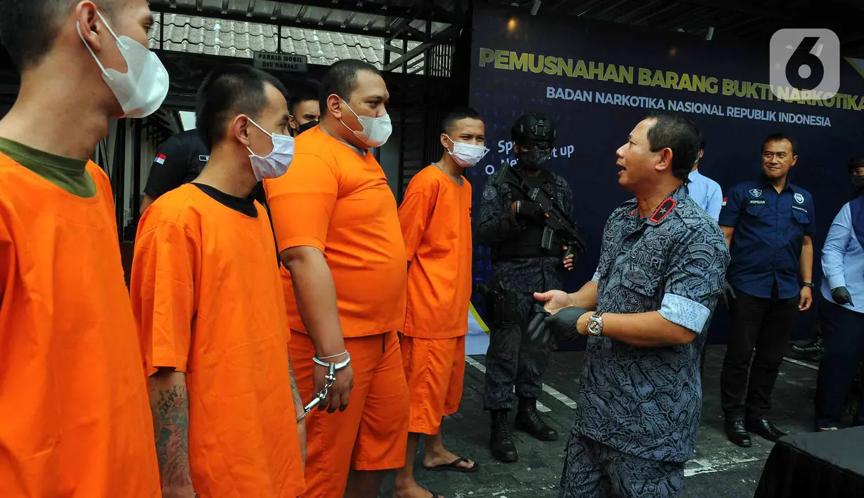 Direktur Pengawasan Tahanan dan Barang Bukti (Wastahti) Badan Narkotika Nasional (BNN) Samudi (kanan) berbincang dengan para tersangka saat pemusnahan barang bukti ganja di Lapangan Gedung BNN, Jakarta, Rabu (18/1/2023). BNN memusnahkan barang bukti 222,697 kilogram ganja dan menangkap empat tersangka berinisial AE alias Adul, RJ, MF, dan G yang merupakan narapidana Lapas Kelas I Tangerang dari pengiriman paket kargo di depan Mall Cijantung. (merdeka.com/Imam Buhori)