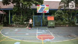 Petugas menyapu halaman Sekolah Dasar Negeri (SDN) Gondangdia 01, Jakarta, Senin (9/5/2022). Pemerintah memperpanjang libur sekolah selama tiga hari di tiga provinsi, khususnya di DKI Jakarta, Jawa Barat, dan Banten. Artinya, siswa di daerah tersebut yang seharusnya masuk sekolah pada Senin 9 Mei 2022 menjadi Kamis 12 Mei 2022 mendatang. (Liputan6.com/Faizal Fanani)